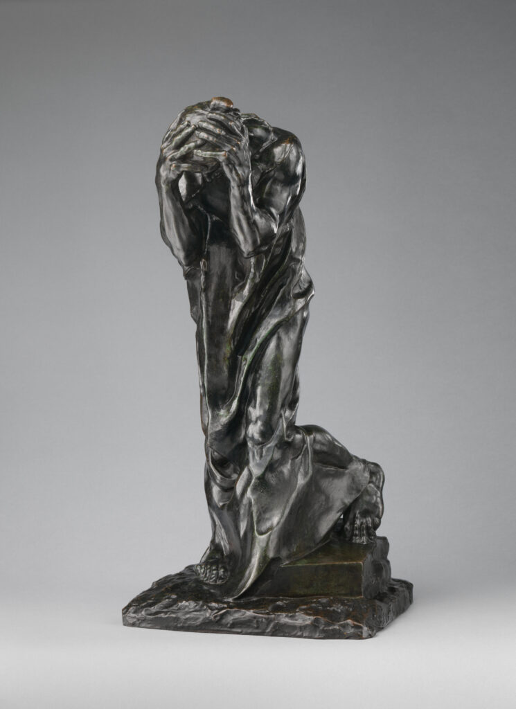 Sculpture of a kneeling figure with head buried in hands, expressing grief and sorrow.