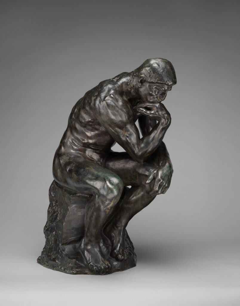 Bronze statue of a man deep in thought, symbolizing reflection and meaning
